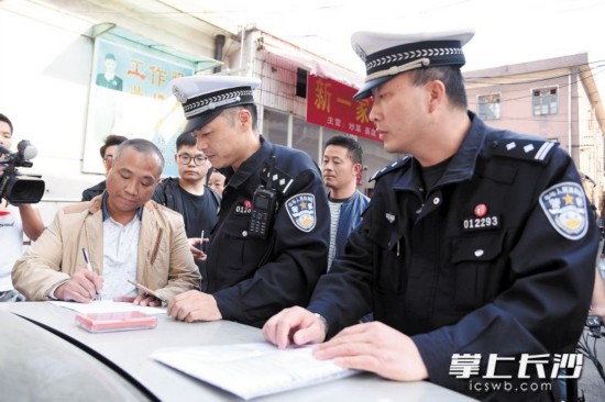 昨日,芙蓉交警大隊民警依法對存在違規行為的金蘋果停車場開出罰單。這是長沙交警向違規停車場開出的首張罰單。 長沙晚報記者劉琦攝