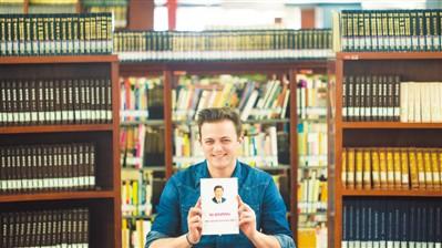 中國僑網圖為歐坤向記者展示他新買的《習近平談治國理政》一書。 本報記者 楊俊峰攝