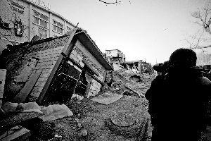 一間倒塌在坑內的房屋已經被回填的沙土埋了一半。 張靜雅 攝