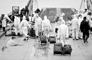 搜救人員將遇難者遺物轉運出艙。新華社記者 白禹/攝