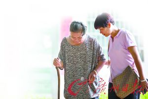 二女兒攙扶著溫銀英老人出門走動。