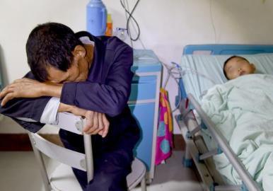 10月25日,四川大學華西第二醫院,同樣中毒的爺爺守在孫兒病床前。