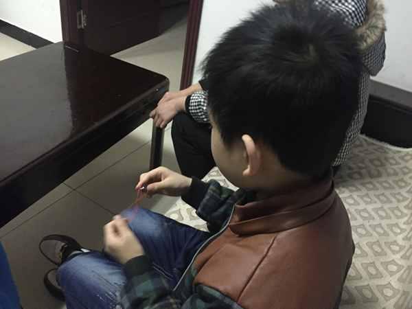 11月30日,沙坪壩,派出所里,10歲的小峰(化名)擺弄著一個小玩具。上游新聞記者 甘俠義 攝