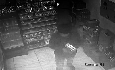 嫌疑人在便利店將貨物拿至收銀臺(tái)準(zhǔn)備搶劫。