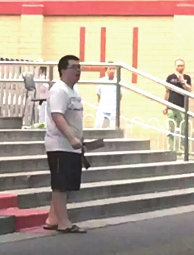 左一:男子當(dāng)街手持兩把菜刀。