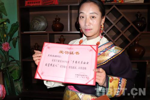 拿著榮譽證書的果拉卓瑪拉姆。攝影:孔夏